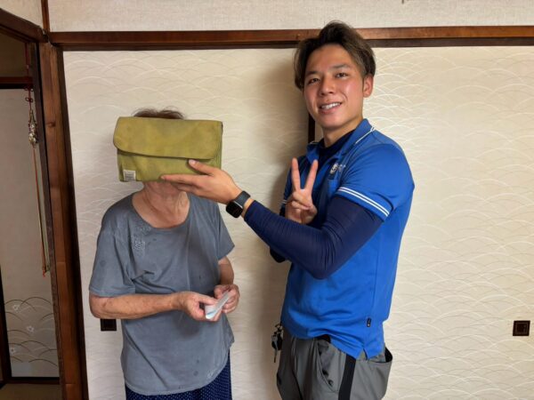 寝屋川市のマンション前でタンスや下駄箱の回収完了後にお客様と笑顔で並ぶイーブイの作業スタッフ