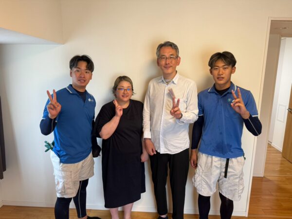 豊中市のマンション前でダブルベッドと不用品回収完了後にお客様と笑顔で並ぶイーブイの作業スタッフ