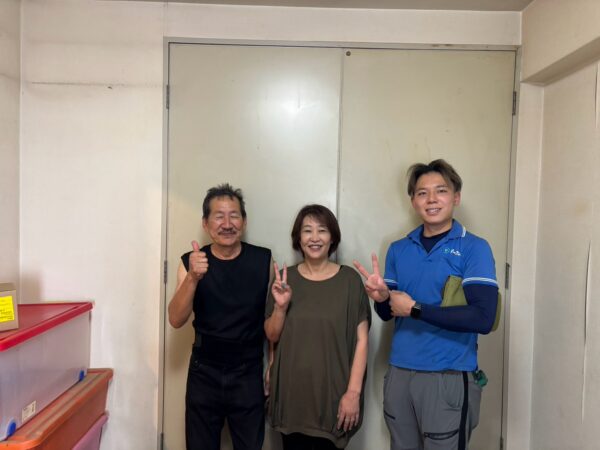 尼崎市のマンション前でタンスや学習机の回収完了後にお客様と笑顔で並ぶイーブイの作業スタッフ