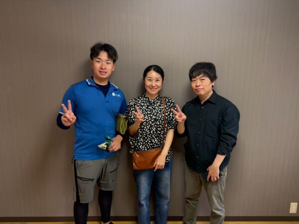 大阪市住吉区のマンション前でベッドや家電の階段搬出完了後にお客様と笑顔で並ぶイーブイの作業スタッフ
