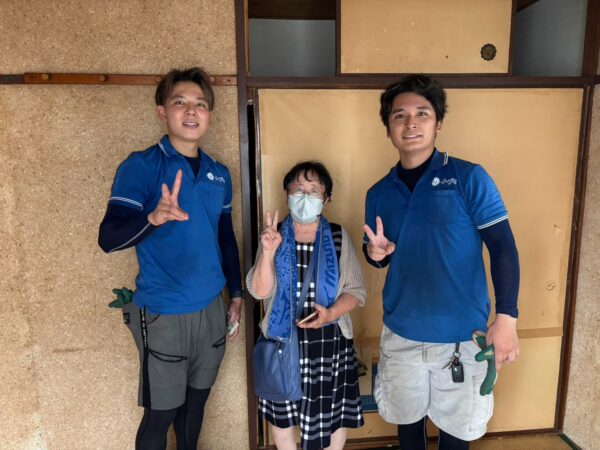 神戸市中央区のアパート前で退去に伴う家財や家電の不用品回収完了後にお客様と笑顔で並ぶイーブイの作業スタッフ