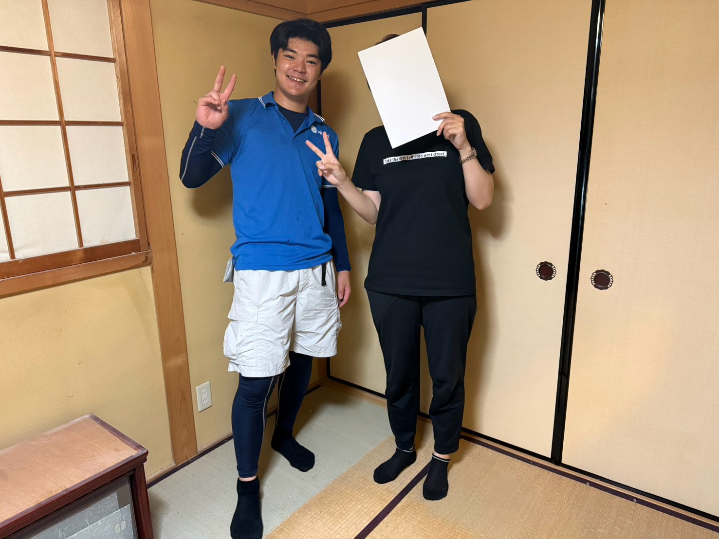 八尾市の戸建て住宅前で屋根裏の不用品回収完了後にお客様と笑顔で並ぶイーブイの作業スタッフ