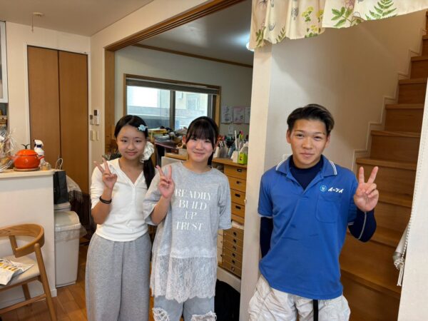 京都府京田辺市の戸建て前で不用品回収完了後にお客様と笑顔で並ぶイーブイの作業スタッフ