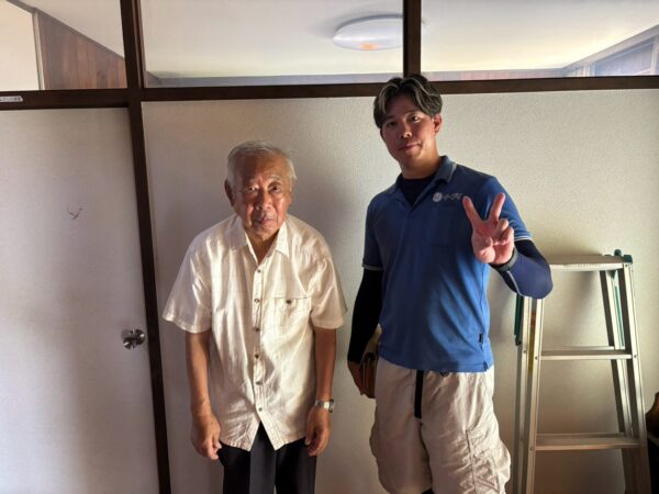 枚方市の一軒家前で遺品整理の家財搬出完了後にお客様と笑顔で並ぶイーブイの作業スタッフ