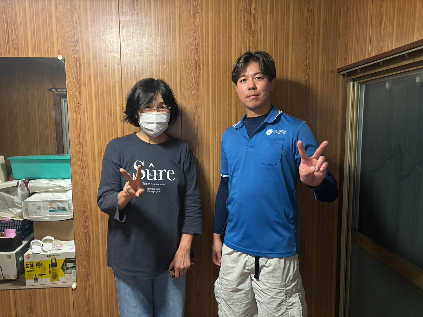 羽曳野市の戸建て住宅前で遺品整理完了後にお客様と笑顔で並ぶイーブイの作業スタッフ