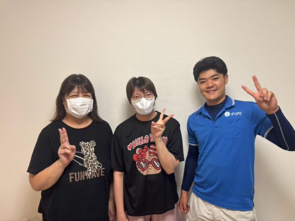 東大阪市のマンション前でベッドやガラステーブルの回収完了後にお客様と笑顔で並ぶイーブイの作業スタッフ