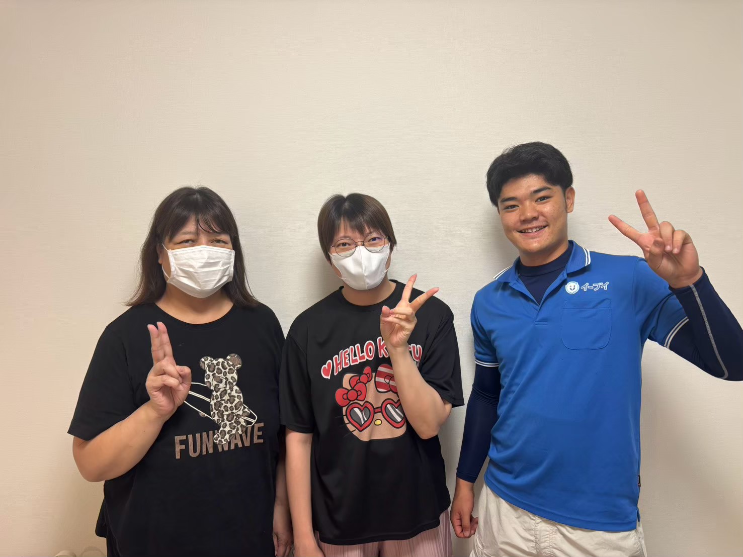東大阪市のマンション前でベッドやガラステーブルの回収完了後にお客様と笑顔で並ぶイーブイの作業スタッフ